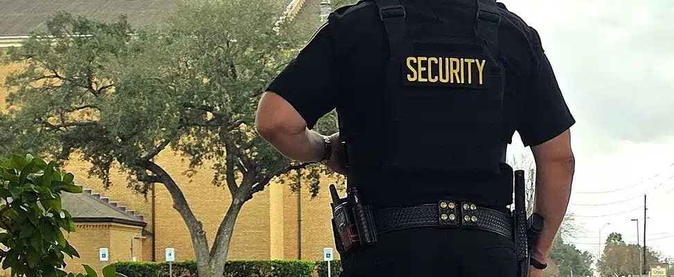 armed-security-guard-houston-img-1 Security guard outside building with trees