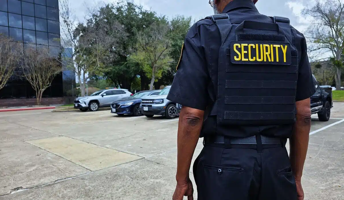 Security guard standing near parked cars.